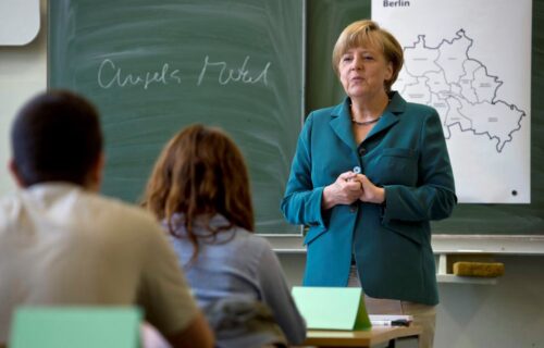 German Chancellor Angela Merkel conducts a lecture, after writing her name on a board, at a classroom in Heinrich Schliemann Gymnasium, a secondary school in Berlin, August 13, 2013. Merkel delivered a lecture to a 12th grade class on the building of the Berlin Wall in August 1961. REUTERS/Odd Andersen/Pool (GERMANY - Tags: POLITICS EDUCATION ANNIVERSARY)